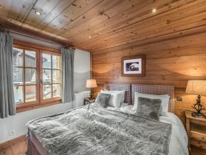 a bedroom with a large bed in a wooden wall at Chalet Megève, 5 pièces, 8 personnes - FR-1-453-12 in Megève