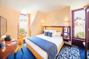 a hotel room with a bed and a desk and a window at Occidental Praha Wilson in Prague +25 photos