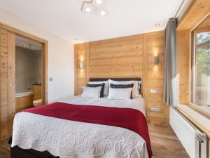 a bedroom with a large bed with wooden walls at Appartement rénové 4 pers. au centre de Megève - Balcon, parking, TV, Wifi - FR-1-453-66 in Megève