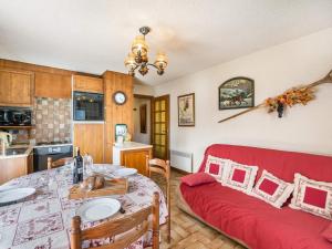 ムジェーヴにあるAppartement Megève, 3 pièces, 4 personnes - FR-1-453-70のリビングルーム(テーブル、赤いソファ付)