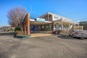 een gebouw waar een auto voor geparkeerd staat bij Edgewater Inn - Biloxi Beach in Biloxi