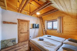 - une chambre avec un lit dans une pièce dotée de plafonds en bois dans l'établissement Chata Líška JASNA, à Liptovský Mikuláš