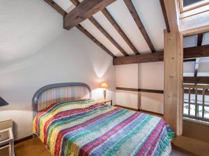 ムジェーヴにあるAppartement Megève, 3 pièces, 4 personnes - FR-1-453-89のベッドルーム1室(カラフルな毛布付きのベッド1台付)