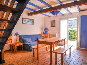 LocmariaにあるMaison cosy 2 chambres avec jardin, proche plage et côte sauvage, idéale pour famille - FR-1-418-145のテーブルと青いソファのあるリビングルーム +14枚の写真