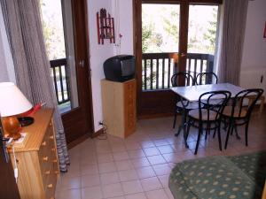 a living room with a table and chairs and a television at Studio Megève, 1 pièce, 3 personnes - FR-1-453-116 in Megève