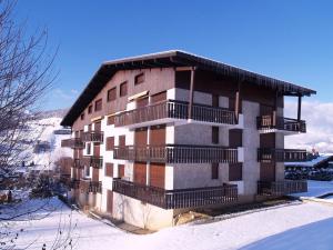 un bâtiment avec balcon dans la neige dans l'établissement Studio Megève, 1 pièce, 2 personnes - FR-1-453-124, à Megève