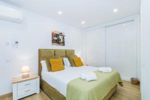 een slaapkamer met een bed en een tafel met een nachtkastje bij Vista Bonita by Algarve Golden Properties in Lagos