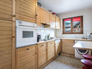 una cucina con armadi in legno e un apparecchio bianco di Appartement Megève, 3 pièces, 4 personnes - FR-1-453-65 a Megève