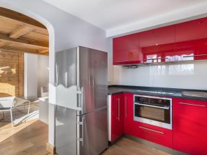 ムジェーヴにあるAppartement Megève, 2 pièces, 4 personnes - FR-1-453-68のキッチン(赤いキャビネット、ステンレス製の冷蔵庫付)