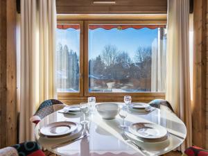 un tavolo bianco con piatti e bicchieri da vino di fronte a una finestra di Appartement Megève, 2 pièces, 4 personnes - FR-1-453-68 a Megève