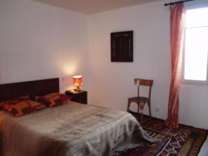 a bedroom with a bed and a chair and a window at Maison Sauzon, 3 pièces, 5 personnes - FR-1-418-160 in Sauzon