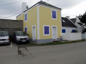 a yellow house with two cars parked in front of it at Maison Sauzon, 3 pièces, 5 personnes - FR-1-418-160 in Sauzon