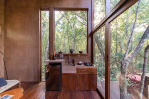 a bathroom with a sink and a large window at OJO DE AGUA. Design+pool. Vive la auténtica selva! in Tulum