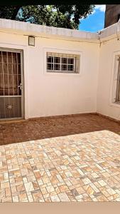 Edificio blanco con 2 ventanas y patio de ladrillo en M&D alojamiento en La Rioja