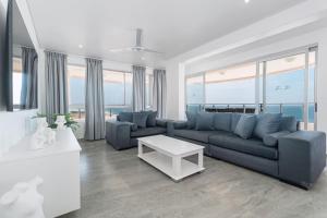 a living room with a blue couch and a table at 401 Bermuda Endless ocean views in Ballito