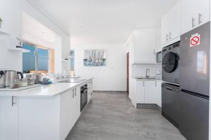 een grote keuken met witte kasten en apparaten bij 401 Bermuda Endless ocean views in Ballito