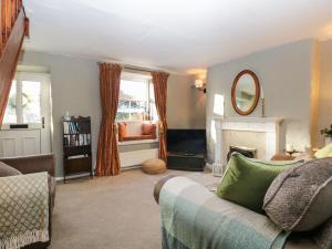 uma sala de estar com um sofá e uma lareira em Lavender Cottage em Grange Over Sands
