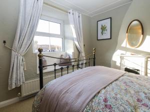 um quarto com uma cama e uma janela em Lavender Cottage em Grange Over Sands