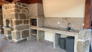 una cucina in pietra con lavandino e piano cottura di 6 bedroom countryhouse with pool - Casa do Sepião a Vinhal