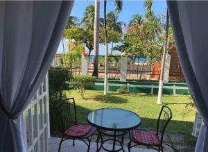 a patio with a glass table and chairs and palm trees at Deluxe SandCastles Condos in Ocho Rios