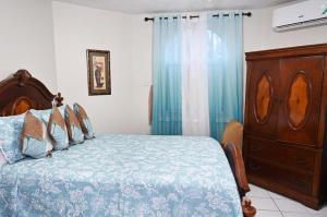a bedroom with a bed and a wooden dresser at Deluxe SandCastles Condos in Ocho Rios
