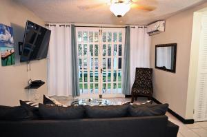 a living room with a couch and a large window at Deluxe SandCastles Condos in Ocho Rios