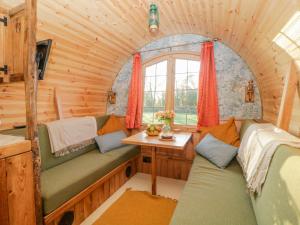 een kamer met een bank en een tafel in een hut bij The Wagon at Burrow Hill in Ottery Saint Mary