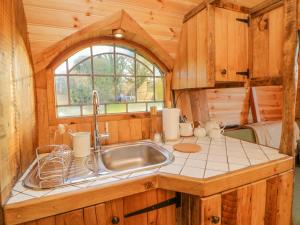 a kitchen with a sink in a log cabin at The Wagon at Burrow Hill in Ottery Saint Mary