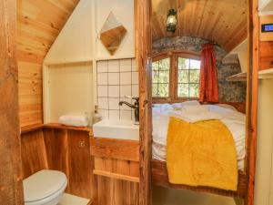 a bathroom with a bed and a sink and a toilet at The Wagon at Burrow Hill in Ottery Saint Mary
