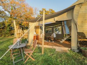 a tent with a table and chairs in a yard at The Wagon at Burrow Hill in Ottery Saint Mary