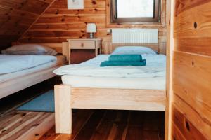 1 dormitorio con 2 camas en una cabaña de madera en HORBACZÓWKA, en Czerwonki