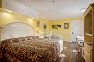 a hotel room with a bed and a desk at Edgewater Inn - Biloxi Beach in Biloxi