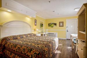 Habitación de hotel con cama y escritorio en Edgewater Inn - Biloxi Beach en Biloxi