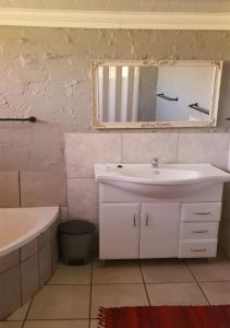 een badkamer met een wastafel en een spiegel bij Perdehoek Venue in Lichtenburg