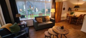a living room with a couch and a table at Marry's boshuisje in Dalfsen