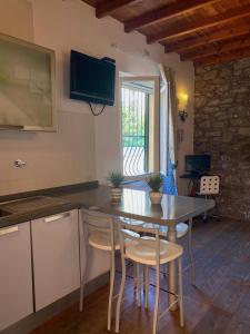 - une cuisine avec une table et des chaises dans la chambre dans l'établissement Clelia Apartments - Deiva Marina, à Deiva Marina