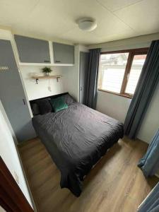 1 dormitorio con 1 cama en la esquina de una habitación en Gezellig chalet op de prachtige Veluwe, en Putten