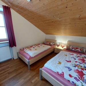 a bedroom with two beds and a wooden ceiling at Ferienwohnung Holzmaier in Bad Aibling
