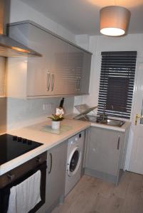 a kitchen with a washer and dryer on a counter at Kelpies Serviced Apartments- Cromwell Apt in Falkirk
