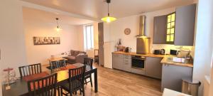 eine Küche und ein Wohnzimmer mit einem Tisch und Stühlen in der Unterkunft Maison tout confort avec jardin - CHANTILLY, SENLIS, PARC ASTERIX, PARIS CDG in Avilly-Saint-Léonard