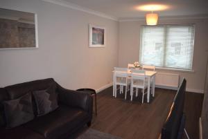 a living room with a couch and a table at Kelpies Serviced Apartments- Cromwell Apt in Falkirk