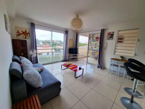 a living room with a blue couch and a table at Appartement charmant aux Trois-Îlets 40 m² avec balcon privé in Les Trois-Îlets