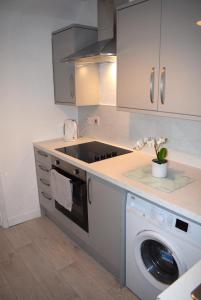 a kitchen with a washer and a washing machine at Kelpies Serviced Apartments- Cromwell Apt in Falkirk