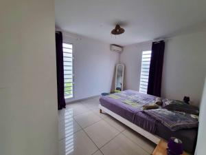 a bedroom with a dog laying on a bed at Appartement charmant aux Trois-Îlets 40 m² avec balcon privé in Les Trois-Îlets