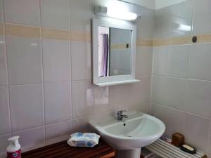 a white bathroom with a sink and a mirror at Appartement charmant aux Trois-Îlets 40 m² avec balcon privé in Les Trois-Îlets +9 photos