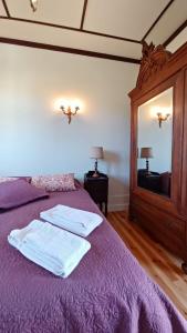 a bedroom with a purple bed with a mirror at Quinta da Lua Nova in Travancinha