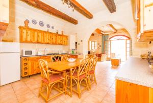 een grote keuken met een houten tafel en stoelen bij Stunning 3 bedroom Farmhouse with pool in Xagħra