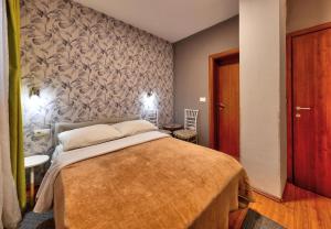 a bedroom with a bed and a wall at Pansion Villa Nur in Mostar