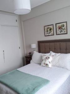een slaapkamer met een wit bed met 2 kussens bij Muy agradable departamento. Bien ubicado, luminoso in San Miguel de Tucumán
