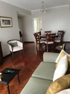 een woonkamer met een bank en een tafel en stoelen bij Muy agradable departamento. Bien ubicado, luminoso in San Miguel de Tucumán
